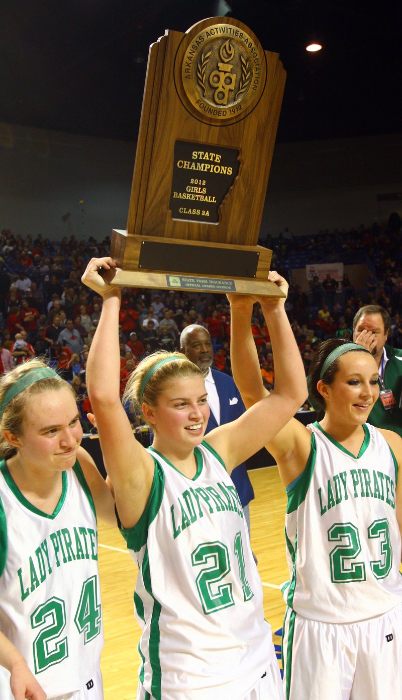 Greenland’s players hold up the trophy after winning the Class 3A 2013 state championship game against Jessieville. Players shown are (front row, left to right) Morgan Miller, Kari Scott and Kelsey Vaughn.