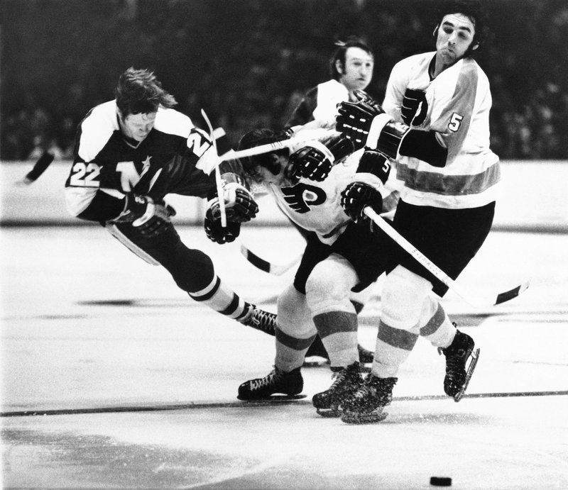 In this March 2 1972, file photo, Minnesota North Stars' Dennis Hextall (22) flips over the back of Philadelphia Flyers Bill Brossart , center, during the first period of an NHL hockey game in Philadelphia. Fifty years ago this week, the owners of the so-called Original Six unanimously approved doubling in size by awarding franchises to Los Angeles, San Francisco/Oakland, Philadelphia, Pittsburgh, St. Louis and Minneapolis/St. Paul. 