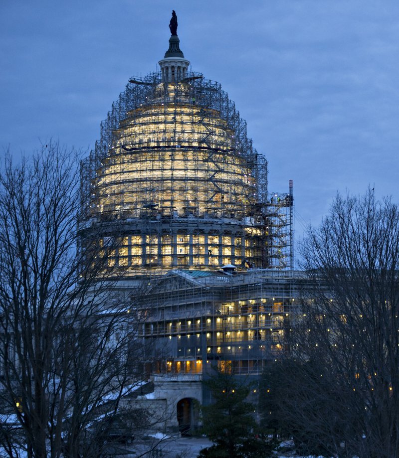 In this Wednesday, Jan. 27, 2016, file photo, work lights illuminate scaffolding around the Senate and the Capitol Dome, part of a long-term repair project, in Washington. 