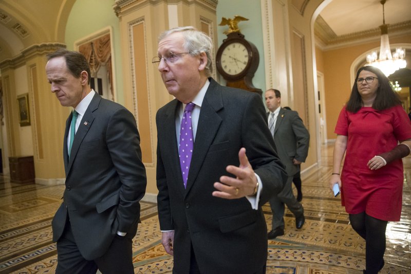 Senate Majority Leader Mitch McConnell, R-Ky., center, walks with Sen. Pat Toomey, R-Pa., left, to the chamber for the vote to impose more stringent sanctions on North Korea for willfully violating international law by pushing ahead with its nuclear weapons program and for what they say are flagrant violations of international law, at the Capitol in Washington, Wednesday, Feb. 10, 2016.