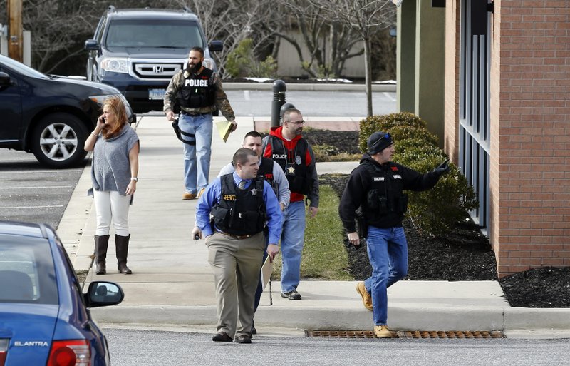 Investigators walk at the scene of a shooting at a shopping center in Abingdon, Md., Wednesday, Feb. 10, 2016. A man opened fire inside a shopping center restaurant during lunchtime. 