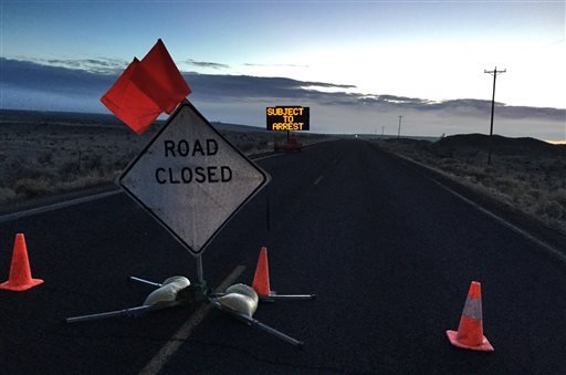 A closed Sod House Lane, about 4 miles outside of the Malheur National Wildlife Refuge in eastern Oregon, displays an electronic sign warning of arrest, Thursday morning, Feb. 11, 2016, near Burns, Ore.