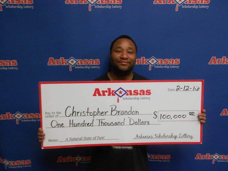 Christopher Brandon of Stuttgart stands with his $100,000 lottery prize. 