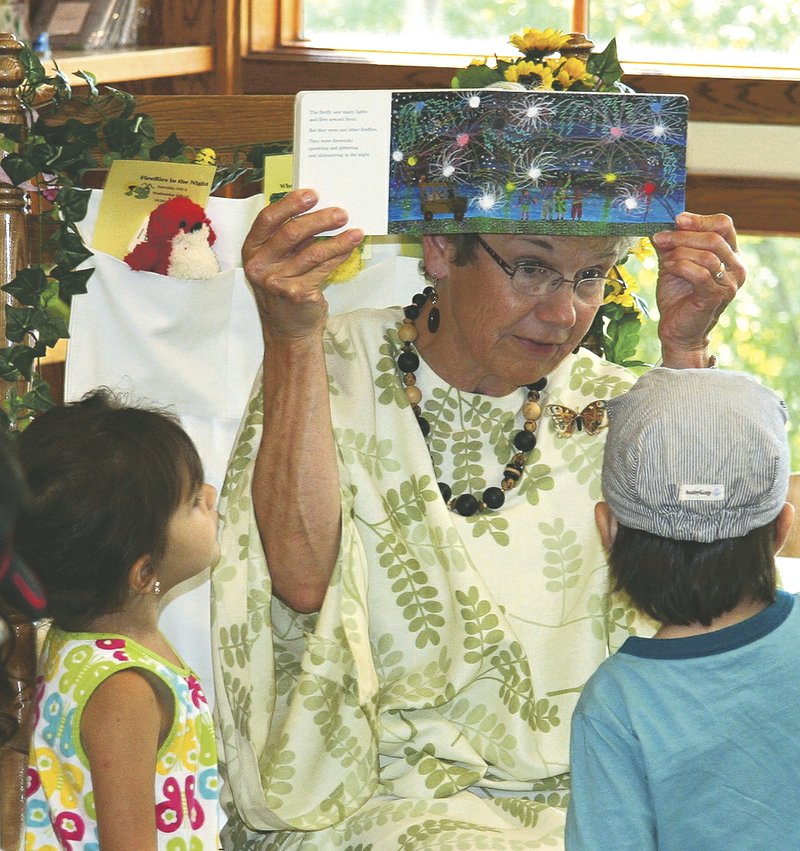 Diane Gately, also known as Mother Nature, shows pictures of the books she's reading to children during a Mother Nature event at Hobbs State Park. She will present a program Saturday titled "Camouflage: How Animals Hide In Plain Sight."