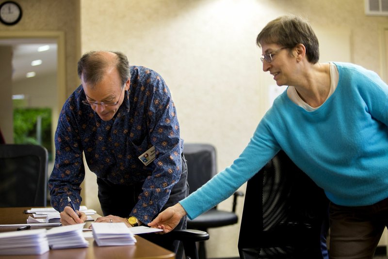 Ken Leonard and Beth Keck, both of Bentonville, prepare letters Thursday at Compton Gardens in Bentonville to be sent to elected officials and government agencies to express Friends of Little Sugar Creek’s opposition to the proposed Lake Bella Vista dam project.