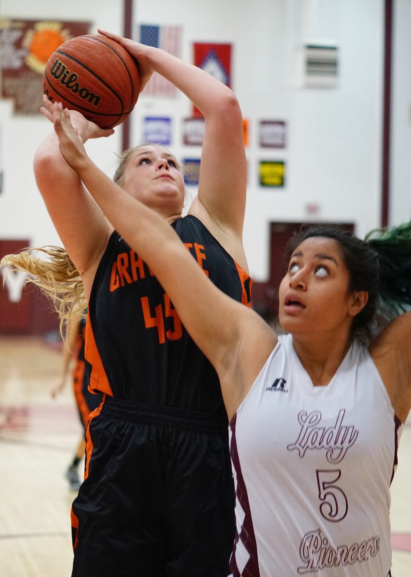 Amanda Pinter, Gravette senior, takes a shot under the basket while guarded by Chastery Fuamatu, Gentry sophomore, during play between Gentry and Gravette at Gentry High School on Friday, Feb. 12, 2016.