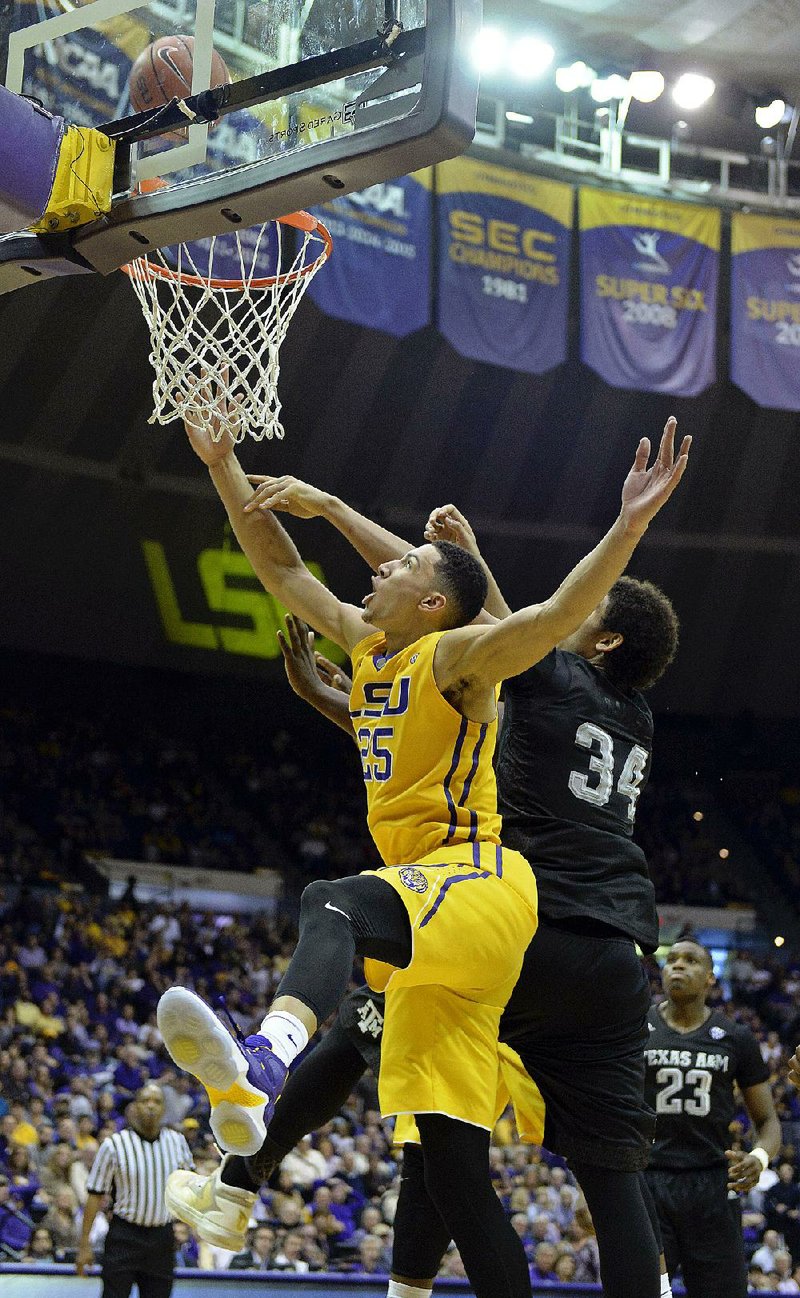 LSU forward Ben Simmons (front) puts up a shot in front of Texas A&M center Tyler Davis (34) during the first half of the Tigers’ 76- 71 victory over the No. 15 Aggies on Saturday in Baton Rouge. Simmons scored 16 points, grabbed 11 rebounds and had 7 assists for the Tigers.