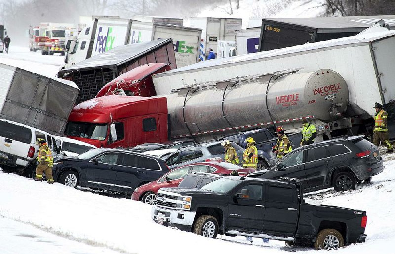 Emergency crews work amid the tangle of a 50-vehicle pileup Saturday on Interstate 78 in Fredericksburg, Pa. 