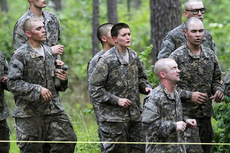 A female soldier (center), and others who qualified last spring to start Ranger School, takes on the Darby Queen, one of the toughest obstacle courses in U.S. Army training, at Fort Benning, Ga. 