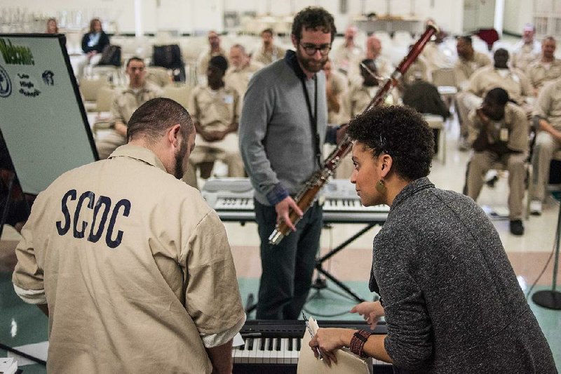 Decoda musicians Brad Balliett (center) and Sarah Elizabeth Charles work with an inmate Tuesday during a music workshop at the Lee prison in Bishopville, S.C. 