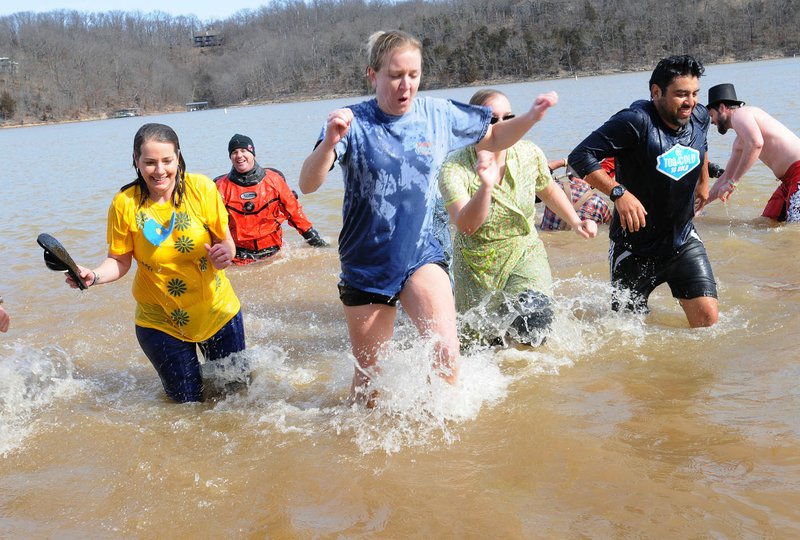  Stacey French (center) runs from the water with her teammates after taking a swim Saturday at the Polar Plunge to benefit Special Olympics Arkansas. Teams of plungers braved the 45-degree water of Beaver Lake to take a dip at the Prairie Creek park swim beach. Air temperature was 39 degrees when the first team hit the water at 11 a.m. Teams from businesses, schools, government agencies, as well as individuals, raised money they donated to Special Olympics.