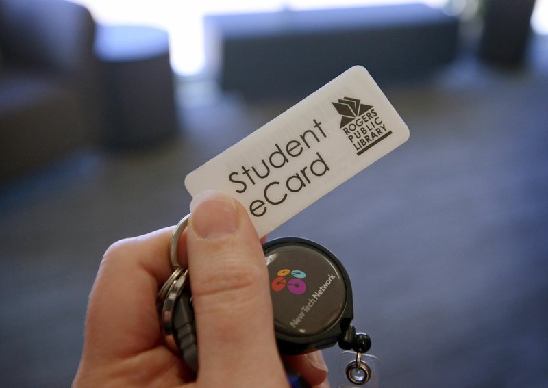 Veronica Thiele, an English teacher at New Technology High School, displays her Rogers Public Library eCard on Thursday at the Rogers school.