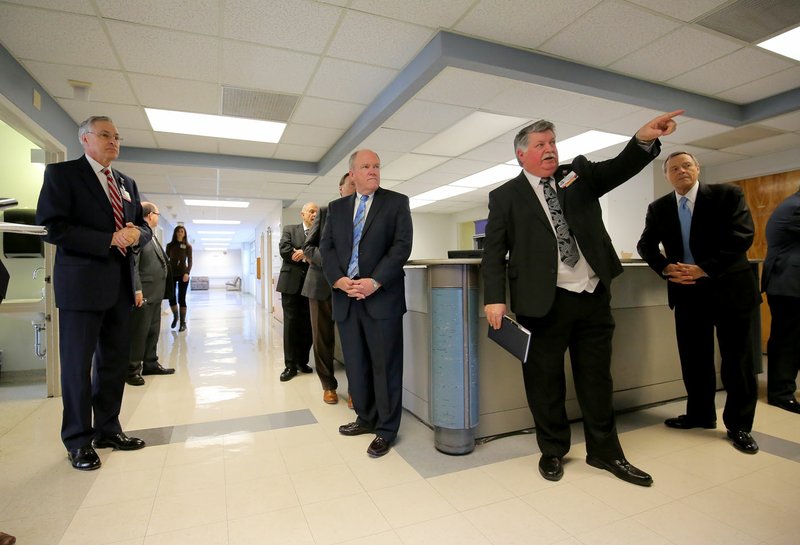 University of Arkansas for Medical Sciences Vice Chancellor Mark Kenneday (foreground) talks with University of Arkansas System board of trustees members as he and Chancellor Dan Rahn (left) give board members a tour of a former nurse’s station area inside UAMS’s Central Building on the Little Rock campus. Kenneday’s tour through the building, built in 1955, was to illustrate deficiencies with the oldest structures on campus.