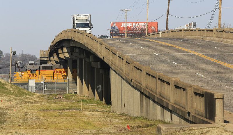 Traffic moves over the Locust Street bridge in North Little Rock on Friday afternoon as a locomotive crosses under the bridge.