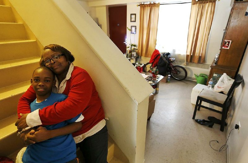 Debra Aldridge sits with her grandson, Mario Hendricks, at her home on Chicago’s South Side. 