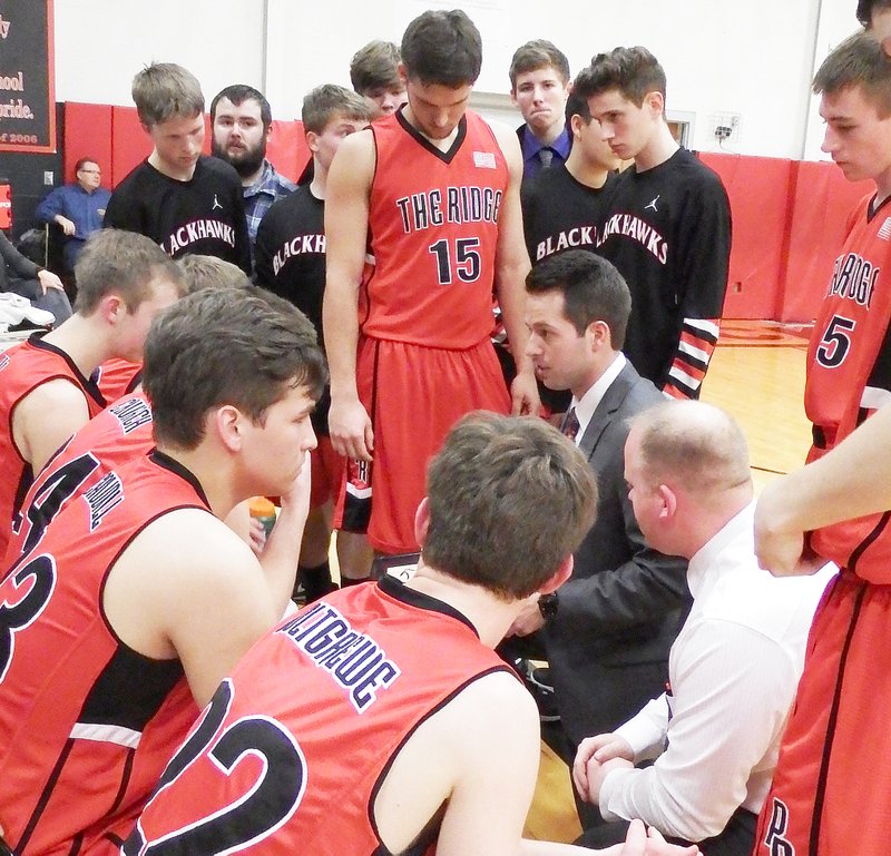 TIMES photograph by Annette Beard Blackhawk basketball coaches Trent Loyd (center) and Heath Neal encourages and instructs the varsity Blackhawks during a time-out of a recent game.