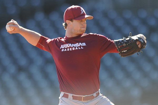 Dominic Taccolini of Arkansas delivers a pitch Friday, Jan. 29, 2016, during practice at Baum Stadium in Fayetteville.
