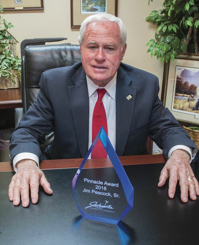 Jim Peacock poses behind his 2016 Pinnacle Award at his real estate office in Jacksonville. He received the honor at the Jacksonville Chamber of Commerce’s annual dinner earlier this month. The award honors someone who has made an impact in the local community.
