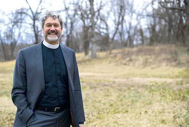 The Rev. Roger Joslin, vicar of All Saints’ Episcopal Church in Bentonville, stands on land slated for the construction of a multi-faith facility where Christians, Jews and Muslims will worship together in Bentonville.