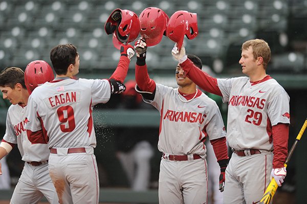 Clark Eagan (9) of Arkansas is congratulated by Rick Nomura (center) and Cullen Gassaway after hitting a 2-run home run against Mississippi Valley State Tuesday, Feb. 23, 2016, during the second inning at Baum Stadium in Fayetteville. 