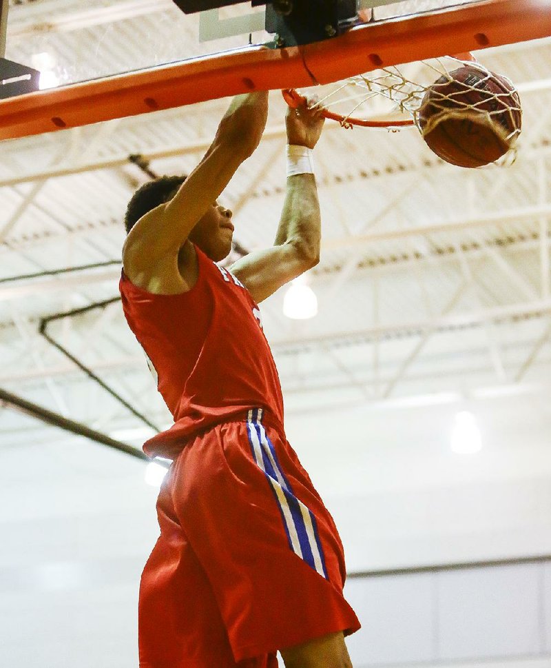 Little Rock Parkview forward Khalil Garland dunks the ball during the first quarter Tuesday night against Little Rock Hall in a 6A-South Conference game at Hall High School. The Patriots beat the Warriors 52-46.