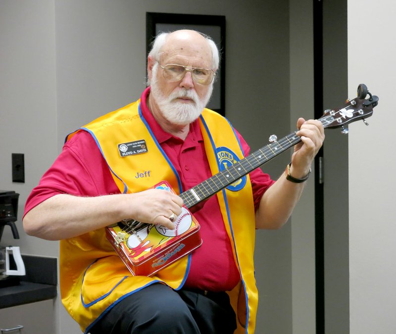 Photo by Susan Holland Jeff Davis, president of the Gravette Lions Club, entertained at the Feb. 18 meeting of the club by playing a tune on a banjo he had made from a Northwest Arkansas Naturals lunchbox. Davis is a member of the Old Town String Band, which plays during the summer at the Gravette Farmers Market.