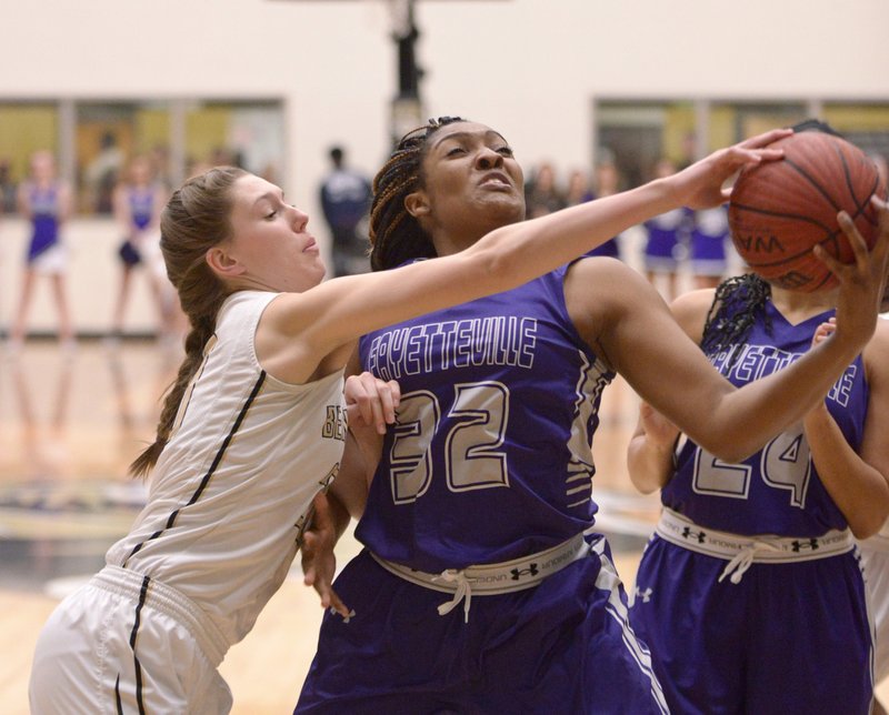 Maren Johnston (left) of Bentonville and Jasmine Franklin of Fayetteville compete for a rebound Friday in Bentonville’s Tiger Arena.