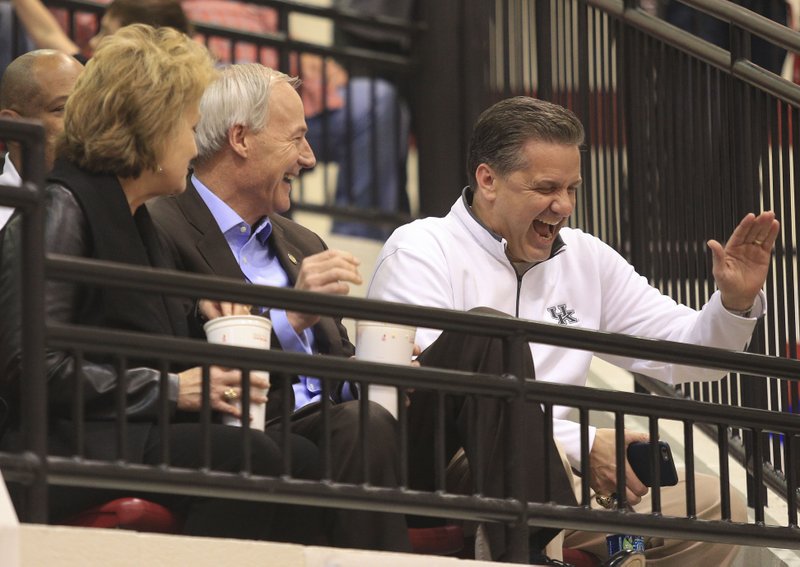 Gov. Asa Hutchinson (middle) and First Lady Susan Hutchinson (left) talk with Kentucky basketball coach John Calipari Thursday night at the 7A state tournament in Cabot.
