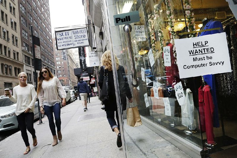 A help-wanted sign hangs in a store window in New York in October. Retailers, restaurants and health care providers drove another solid month of hiring in February, holding the unemployment rate at 4.9 percent.