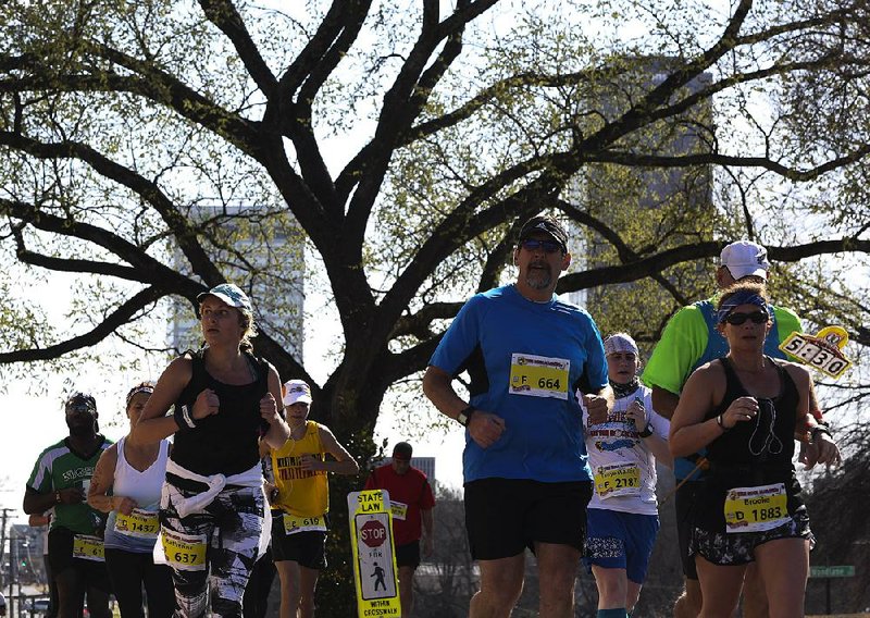 Runners jog down Woodlane Street near the state Capitol during Sunday’s race.