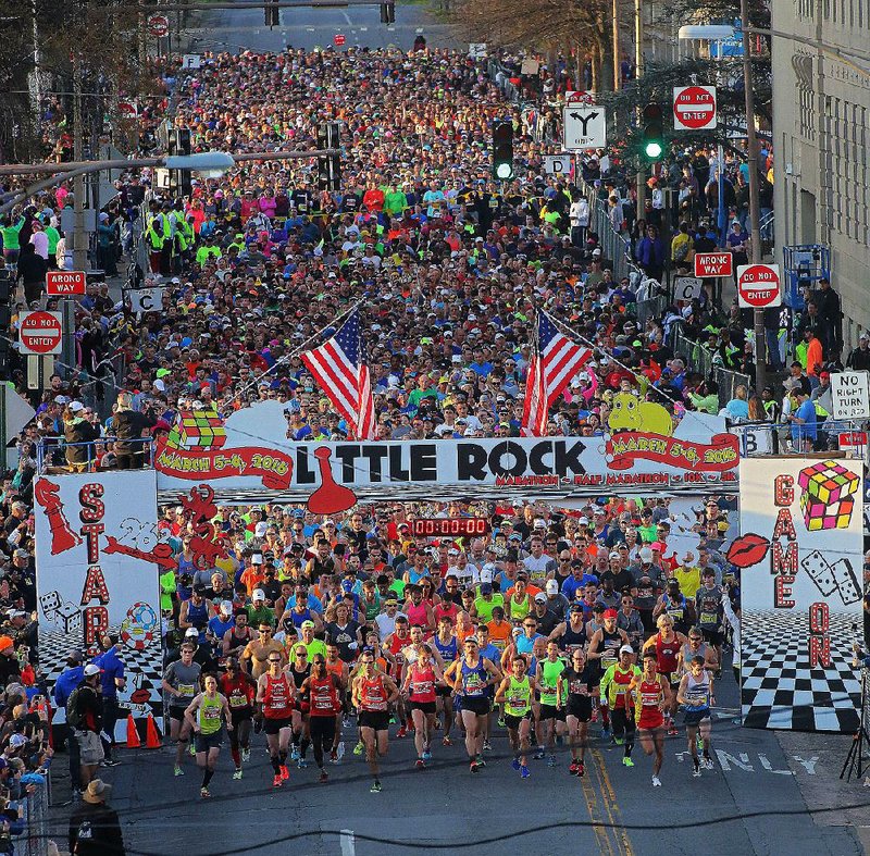 Runners flood from the starting gates north of Scott Street at the beginning of the 2016 Little Rock Marathon. More than 5,000 participated in the 14th running of the marathon and half marathon, which began in downtown Little Rock with a temperature of 45 degrees.