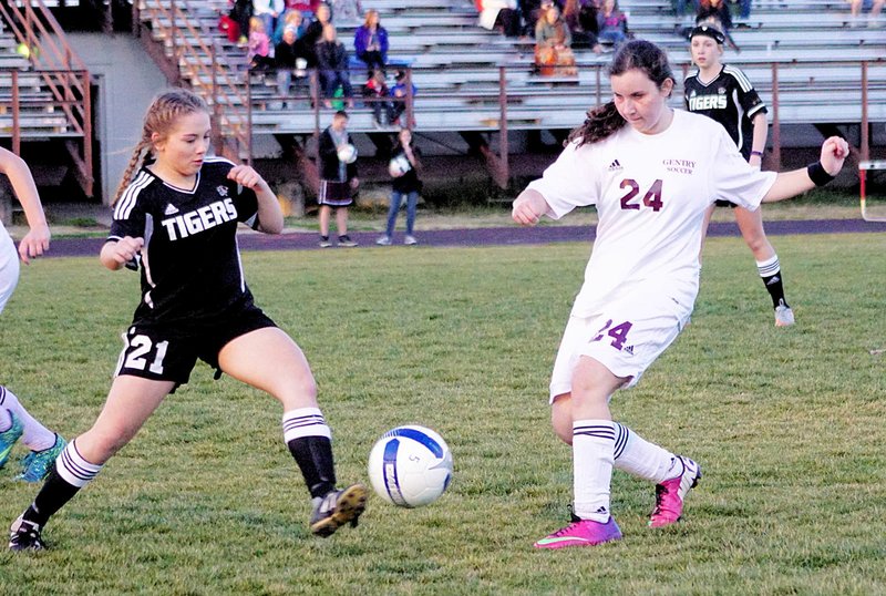 Photo by Randy Moll Karina Appelrath (right) tries to maneuver the ball away from a Bentonville player during Friday&#8217;s non-conference game between Gentry and the Bentonville junior-varsity team in Pioneer Stadium.