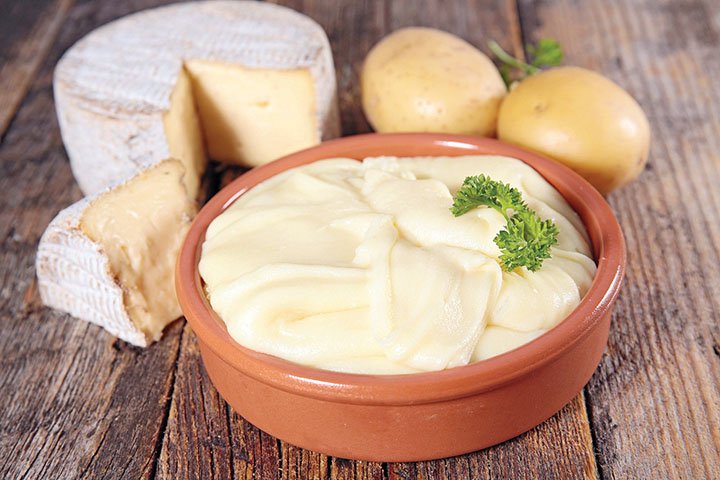 Finely pureed potatoes are flavored with garlic, cream, butter and cheese to achieve a consistency that resembles a thick fondue.