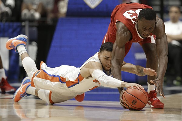 Florida's DeVon Walker, left, and Arkansas's Moses Kingsley, right, chase a loose ball during the first half of an NCAA college basketball game in the Southeastern Conference tournament in Nashville, Tenn., Thursday, March 10, 2016. (AP Photo/Mark Humphrey)
