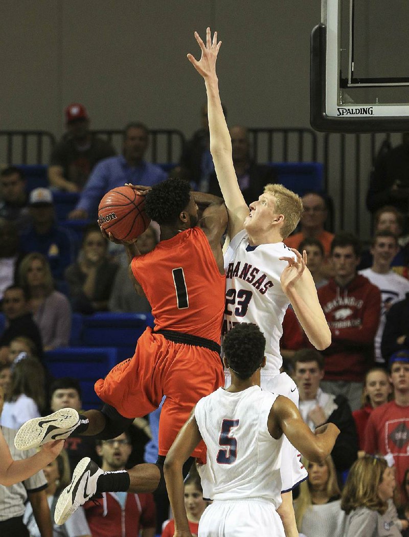 Malvern’s Andre Jones (1) tries to shoot over Baptist Prep defender Connor Vanover during the Class 4A boys state championship game Thursday in Hot Springs. Vanover was named the Class 4A state tournament MVP. More photos are available at arkansasonline.com/galleries.