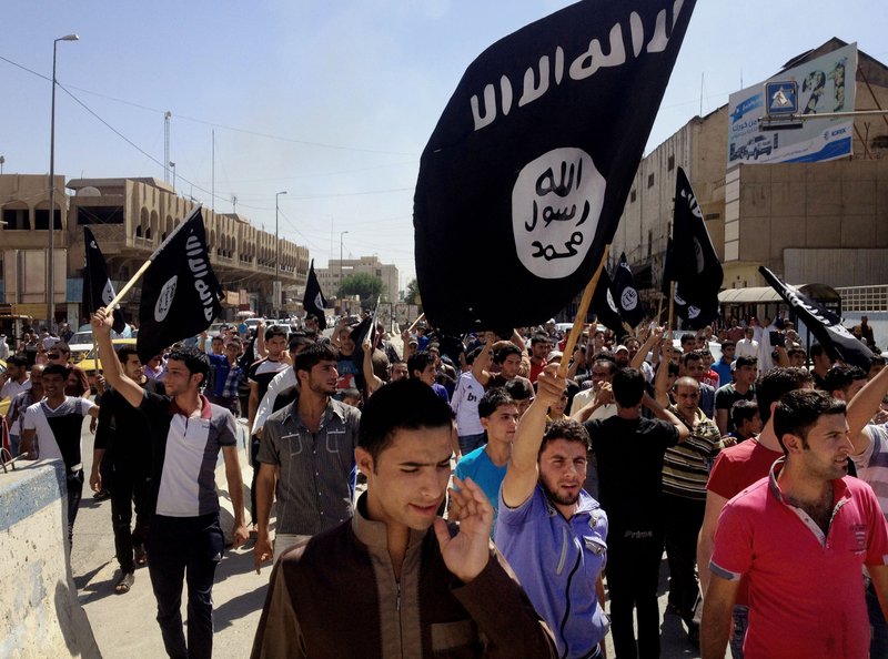 FILE - In this Monday, June 16, 2014 file photo, Demonstrators chant pro-al-Qaida-inspired Islamic State of Iraq and the Levant (ISIL) as they carry al-Qaida flags in front of the provincial government headquarters in Mosul, 225 miles (360 kilometers) northwest of Baghdad, Iraq.  