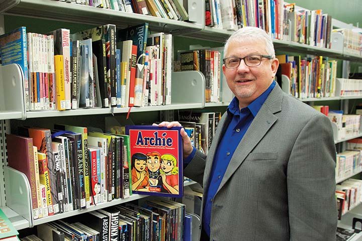 Randy Duncan, professor of communication at Henderson State University, pulls out a book on the Archie comic series in the Greene Room of the Huie Library at Henderson. Duncan, who teaches courses on comics and graphic novels, will speak at the Caddo River Art Guild’s monthly meeting at 6:30 p.m. Thursday at the Arkadelphia Arts Center. The public is invited.