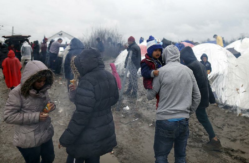 Migrants mill about Friday in a muddy camp on the border between Macedonia and Serbia near the northern Macedonian village of Tabanovce.