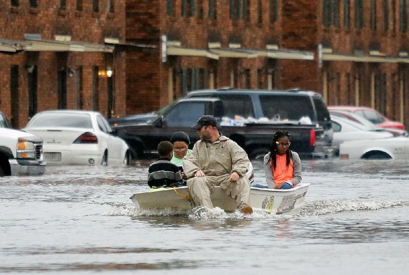 Shatripa Reid, with her daughter, Jamikka Rodgers, and her grandson, Jayvea’l Robinson, are rescued Friday by Tangipahoa Parish sheriff’s deputies from their home in Hammond, La.