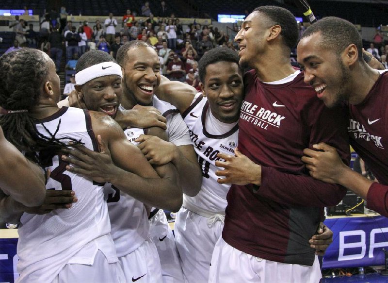 UALR players celebrate after beating Louisiana-Monroe 70-50 in the Sun Belt Conference Tournament final Sunday afternoon in New Orleans. The Trojans rallied from a fi ve-point halftime defi cit to pick up their 29th victory of the season and earn the league’s automatic berth in the NCAA Tournament.