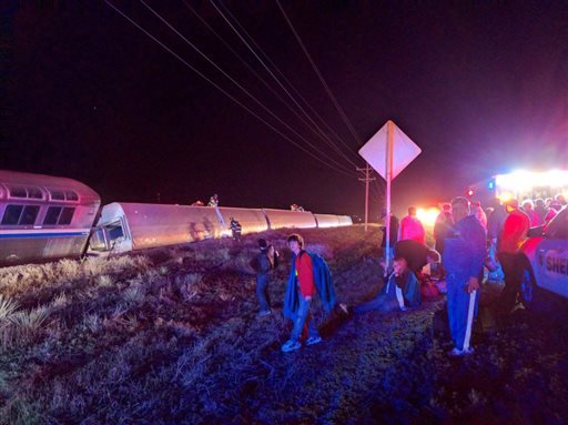 Passengers gather after a train derailed near Dodge City, Kan., on Monday, March 14, 2016. 