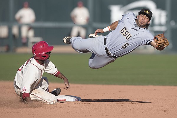Arkansas' Darien Simms slides into second base as Grambling State's Larry Barraza dives for the baseball during the eighth inning of a game Wednesday, March 16, 2016, at Baum Stadium in Fayetteville. 