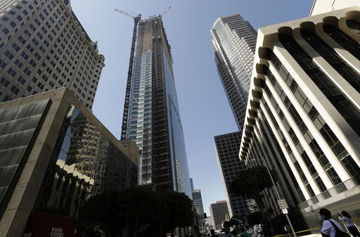 Passers-by look up at the Wilshire Grand Tower on South Figueroa Street where a worker fell to his death Thursday, March 17, 2016.