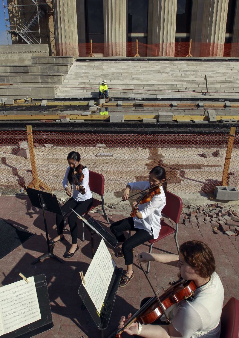 Members of the Arkansas Symphony Orchestra’s Youth Orchestra play outside the construction zone in front of Robinson Center in Little Rock to promote a fundraising campaign. The ASO will return to performing inside the auditorium in November.