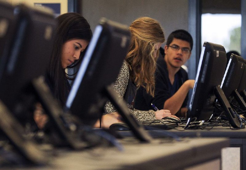 Noemy Sotelo (left), a junior at Bryant High School, takes part in an advanced computer programming class last week. “It’s like a puzzle to solve. It’s like a game — really cool, really interesting,” Sotelo said.