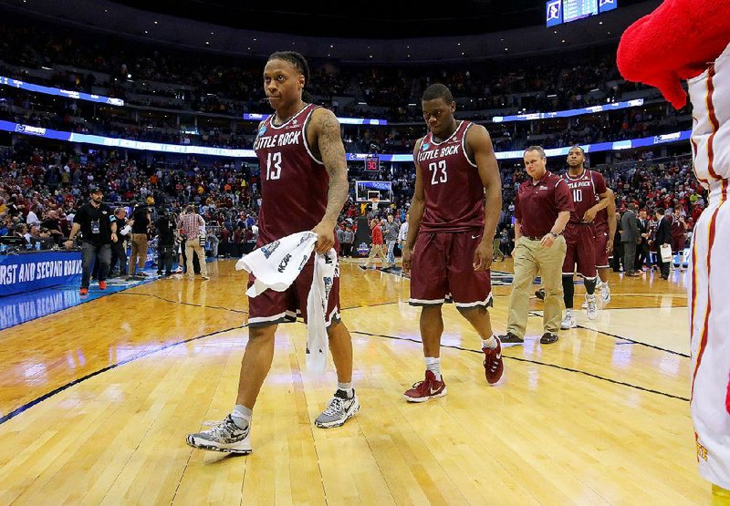 UALR players Marcus Johnson Jr. (left) and Kemy Osse head to the locker room after the Trojans’ season-ending 78-61 loss to Iowa State on Saturday in Denver.