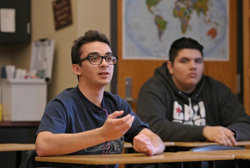 Alex Hamidi shares comments March 11 as classmate Chris Acuna listens during a group discussion in their junior new student seminar class at Bentonville High School.