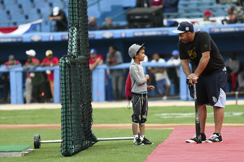 Tampa Bay Rays catcher Rene Rivera (right) talks with Diego Lopez, 9, at Estadio Latinoamericano in Havana on Monday. When President Obama watches the Rays play Cuba’s national team today, it will come at the deepest moment of crisis in more than 50 years for the island’s famed state-run baseball league. But a new U.S. policy may change that.