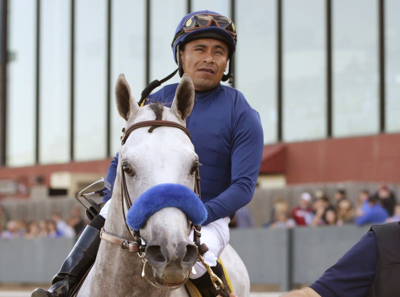 Cupid and jockey Martin Garcia are led to the winners circle after victory in the Rebel Stakes horse race at Oaklawn Park in Hot Springs, Ark., Saturday, March 19, 2016. (AP Photo/Danny Johnston)