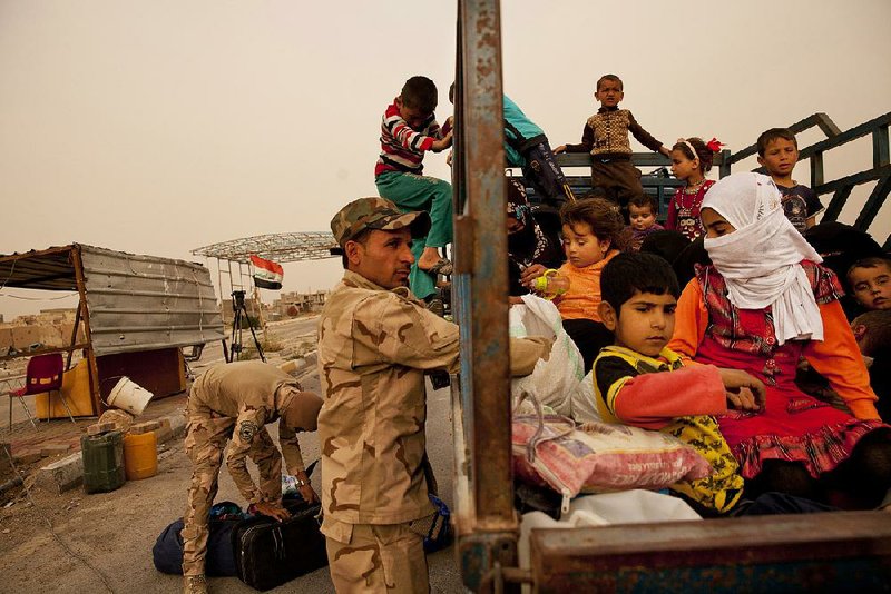 Iraqi soldiers search a convoy of families fleeing the Islamic State-held town of Hit, Iraq, on Sunday at a checkpoint at the western edge of Ramadi. 
